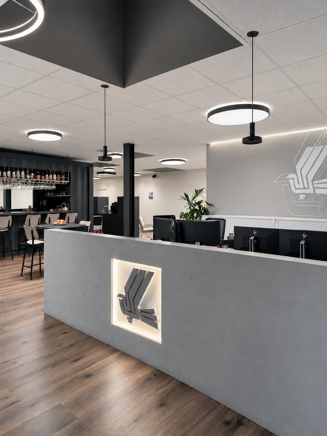 Moderner Büroempfang mit Theke, Arbeitsplätzen und Pendelleuchten
